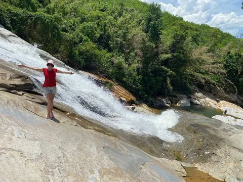 Туристка на гранитных плитах у водопада